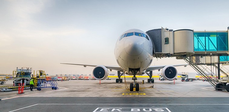 Airplane docked at an airport gate connected by a jet bridge